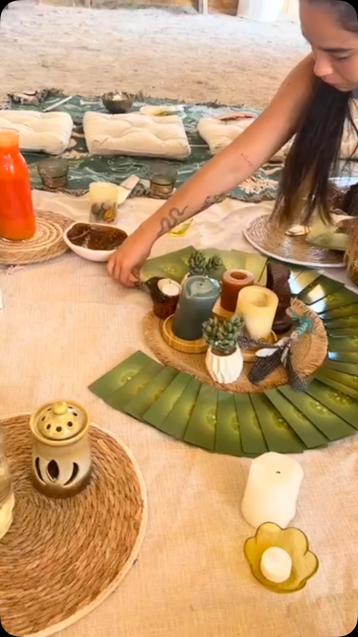 A table laid with candles, tea and a bowl under the trees