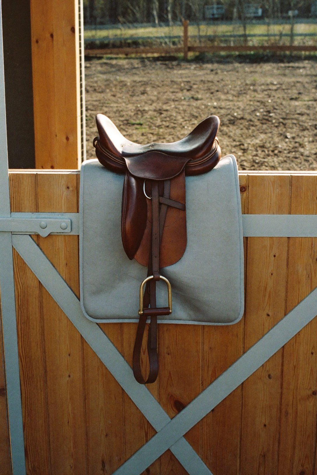 A saddle resting on a stable half-door after a ride