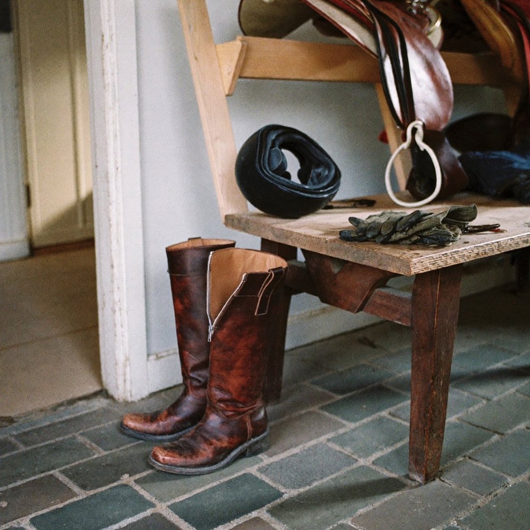 Riding boots on a tack room bench