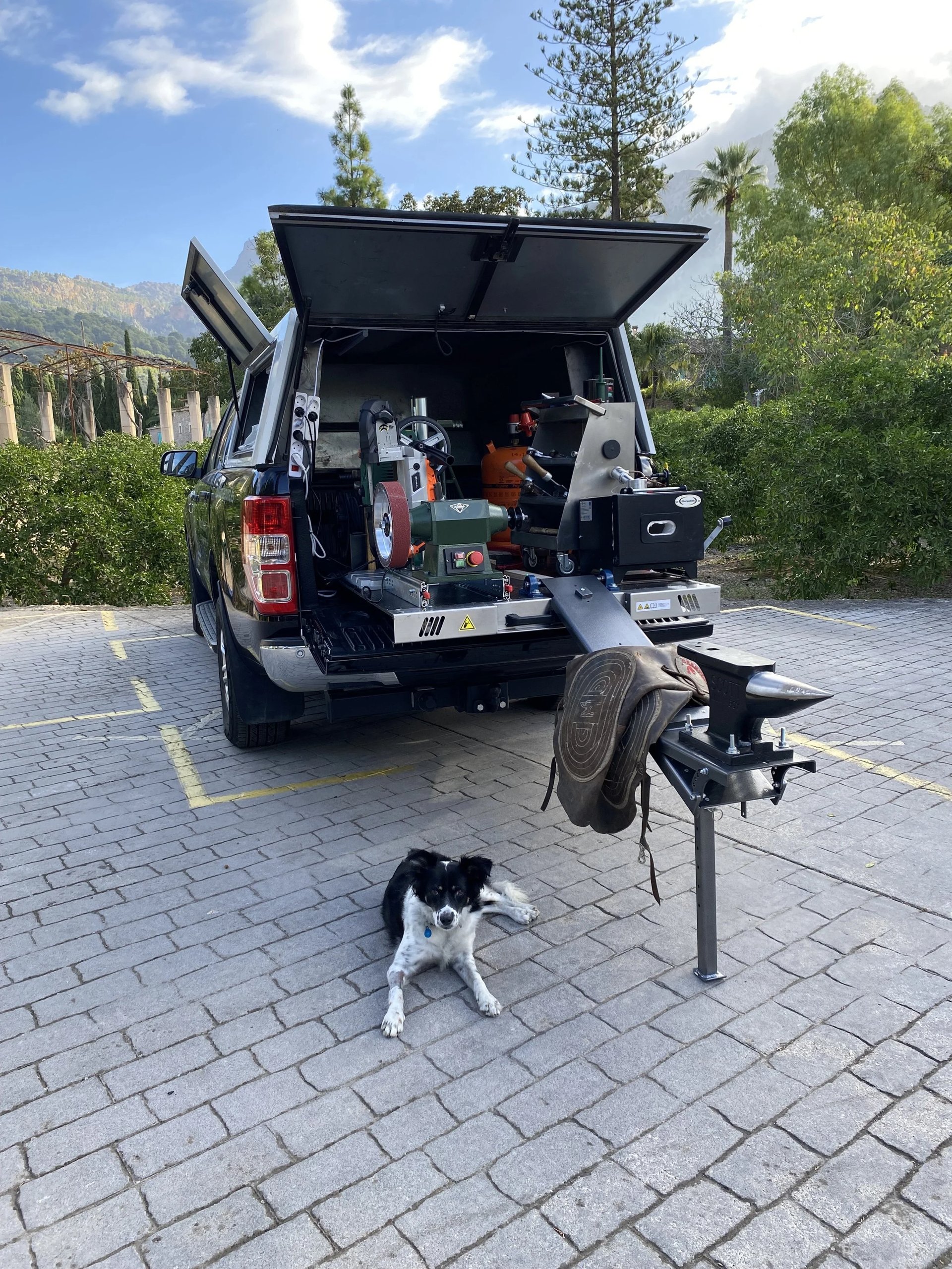 The farrier van open with anvil and dog on a Mallorca driveway