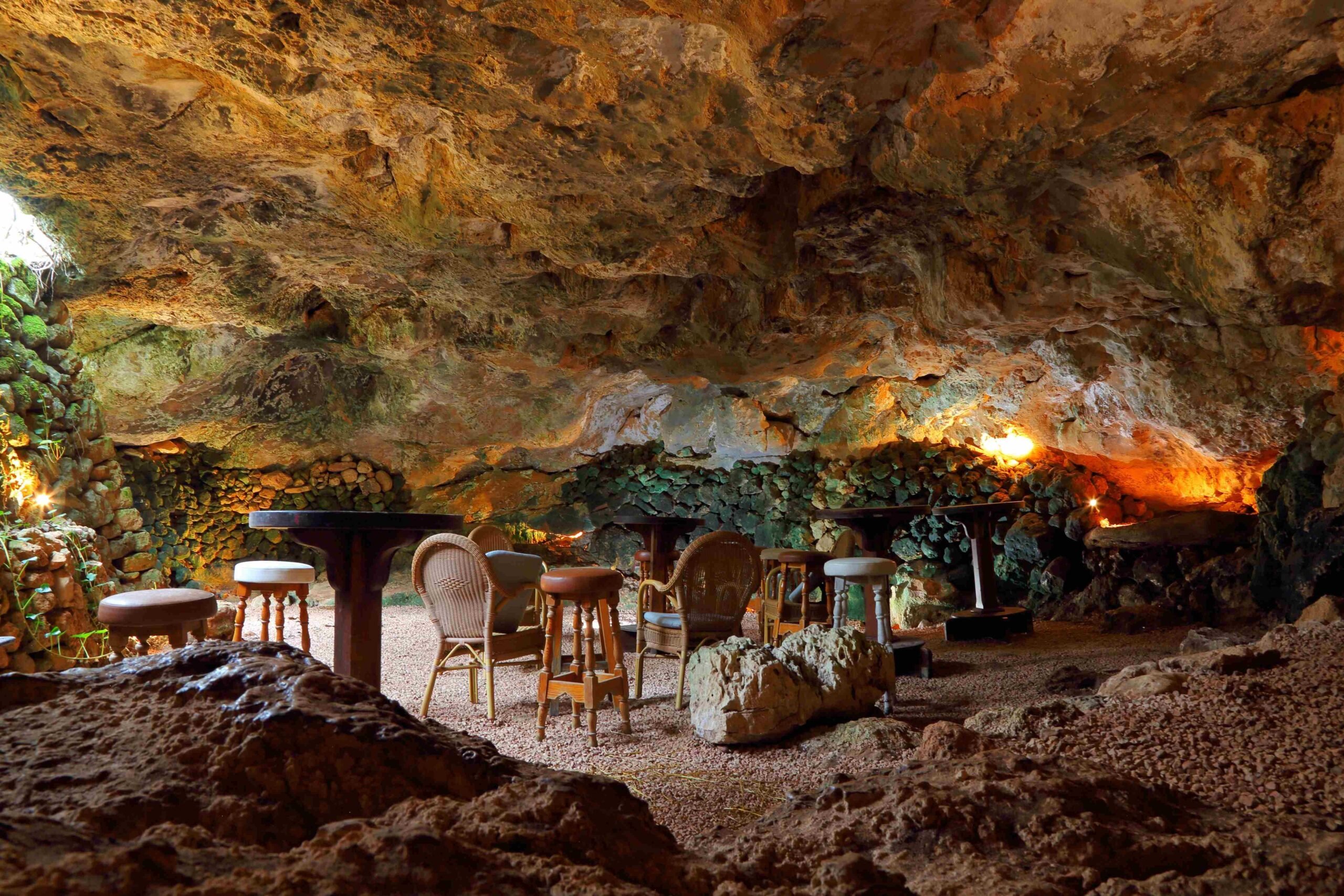 The natural cave at Sa Cova Vella, set with tables and warm light